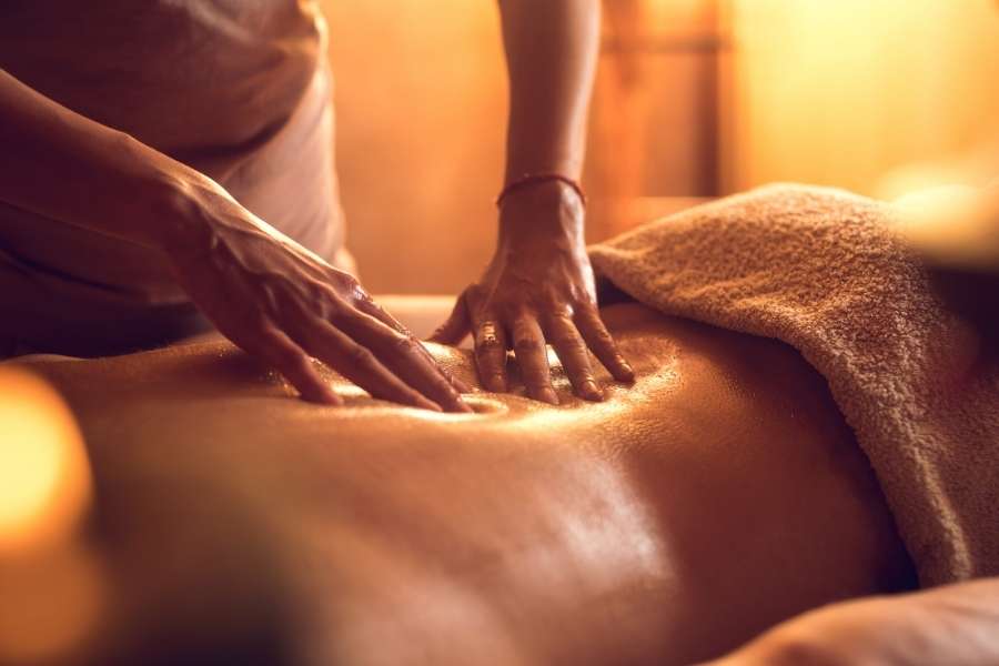 Massage du dos avec huiles chaudes illustrant les techniques de massage